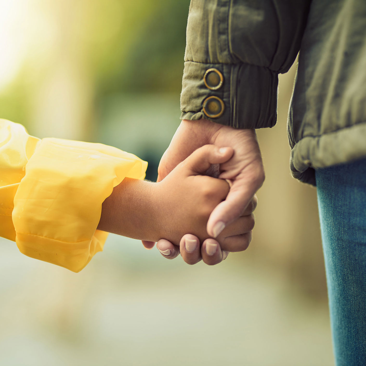 Barn- og voksenhænder der holder hinanden i hånden