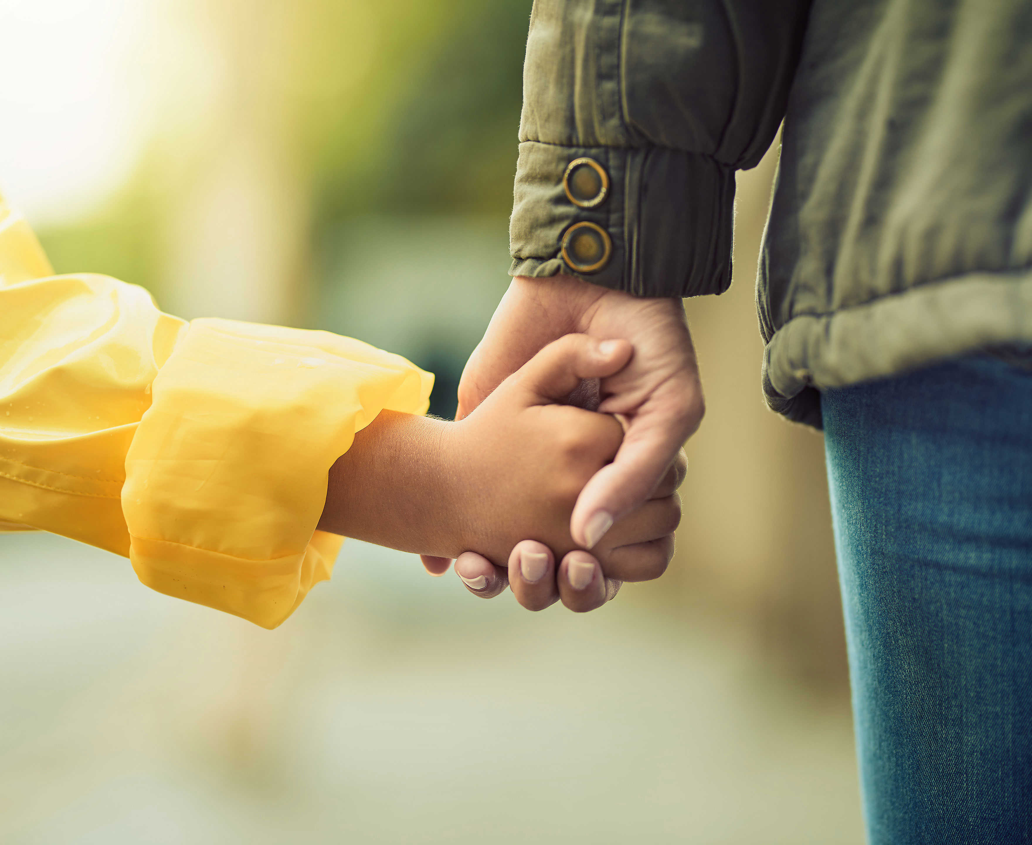 Barn- og voksenhænder der holder hinanden i hånden
