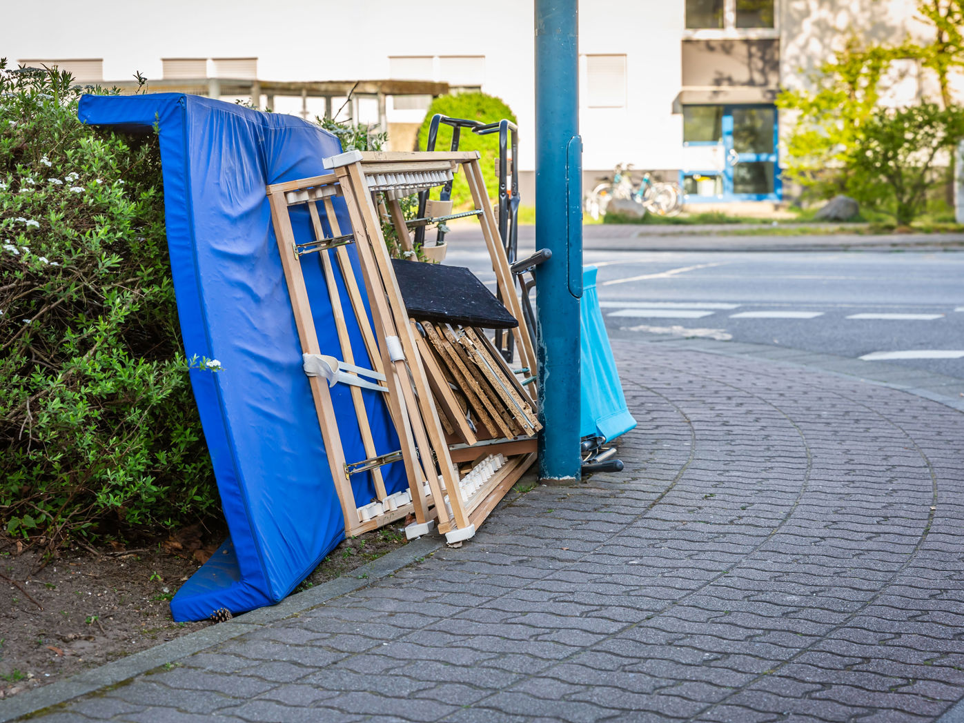 Storskrald i et bed bag en lygtepæl